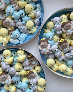 Adorable marshmallow figures in various colors, arranged in three circular boxes.